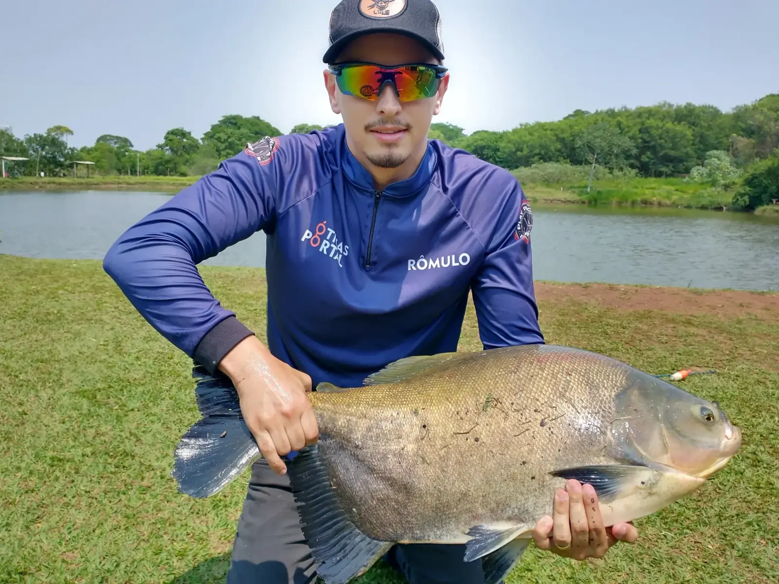 Pescador exibindo tambaqui capturado no Pesqueiro do Parque em Campo Grande/MS